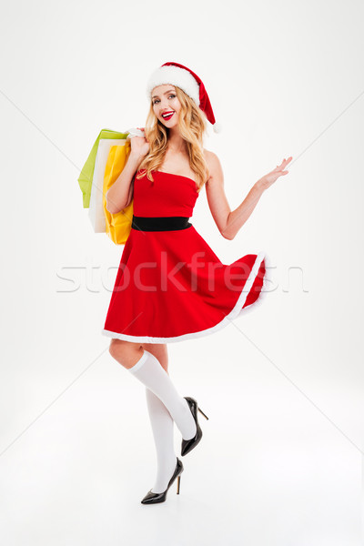 Derűs fiatal nő mikulás jelmez bevásárlótáskák csinos Stock fotó © deandrobot