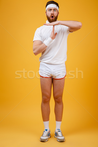 Vertical image of displeased sportsman showing time-out sign Stock photo © deandrobot