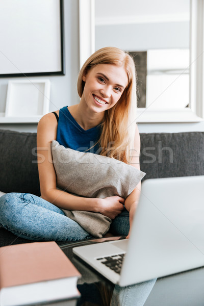 Foto stock: Alegre · mujer · almohada · usando · la · computadora · portátil · sofá