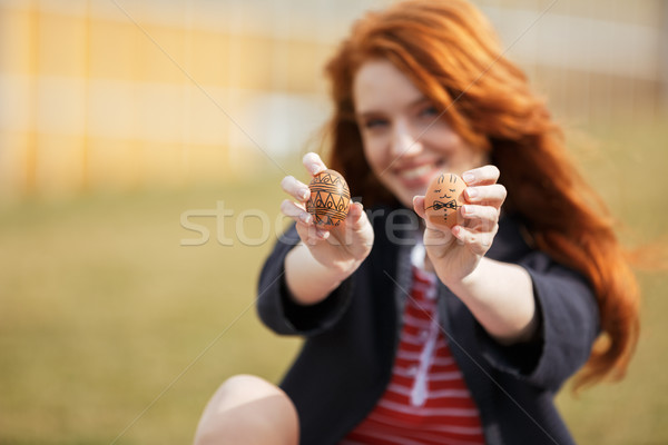 Girl with long ginger hair showing two painted easter eggs Stock photo © deandrobot