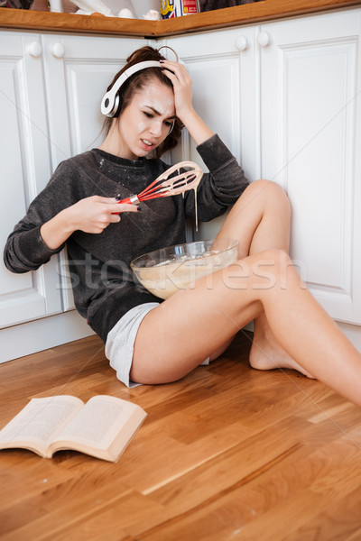 Woman trying to make dough while sitting on the kitchen Stock photo © deandrobot