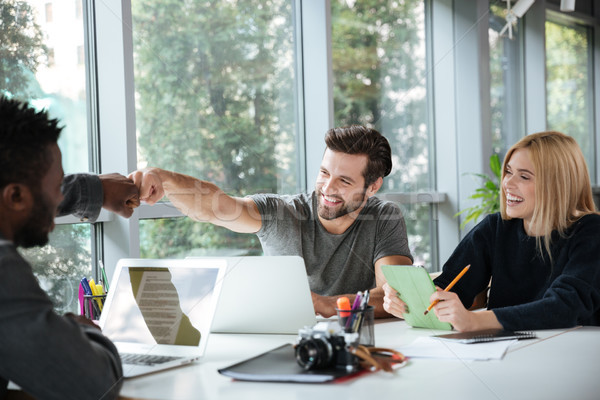 Smiling young colleagues sitting in office coworking Stock photo © deandrobot