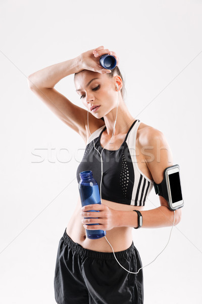 Portrait of a sweaty tired sportswoman in earphones Stock photo © deandrobot