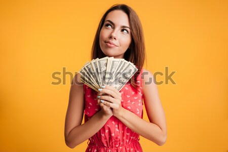 Happy young charming woman in red dress holding bunch of dollar  Stock photo © deandrobot