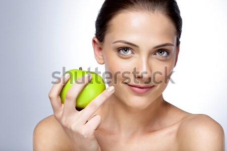 Photo of gorgeous woman with brown hair in bun holding big green Stock photo © deandrobot