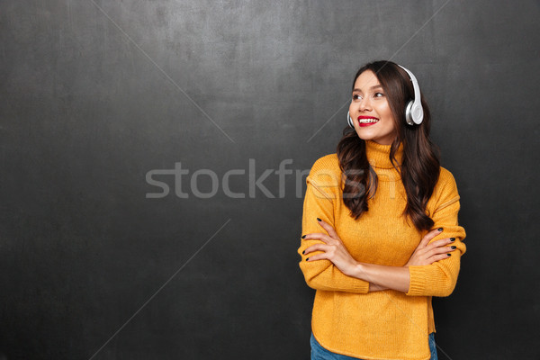 Sorridente morena mulher suéter fones de ouvido escuta Foto stock © deandrobot