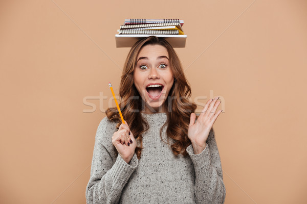Portrait of overjoyed young brunette girl in gray jersey holding Stock photo © deandrobot