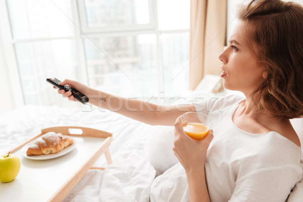Side view picture of serious young lady watch tv Stock photo © deandrobot