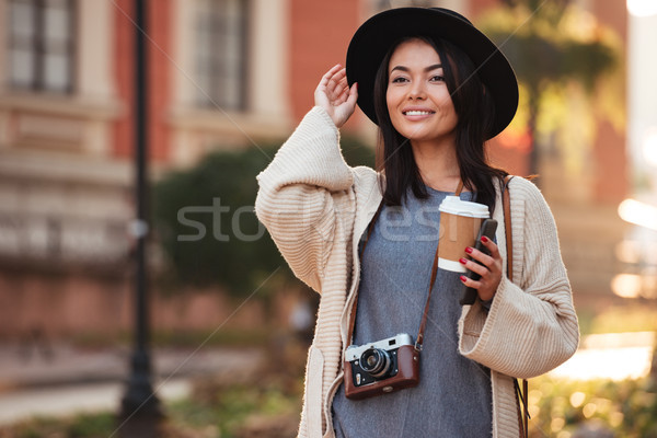 Young charming asian woman in black hat holding takeaway coffee  Stock photo © deandrobot