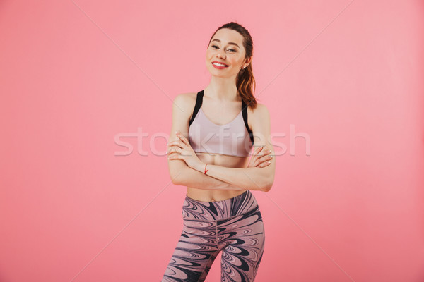 Smiling sportswoman posing with crossed arms and looking at camera Stock photo © deandrobot