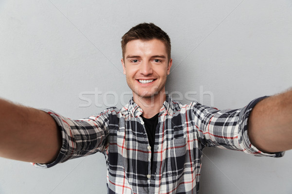 Portrait of a smiling young man in plaid shirt Stock photo © deandrobot