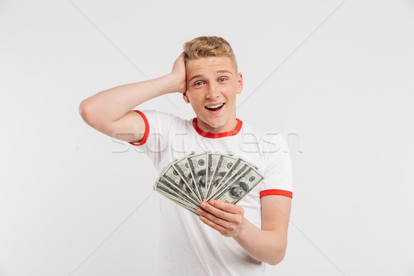 Portrait of a surprised teenage boy holding money Stock photo © deandrobot