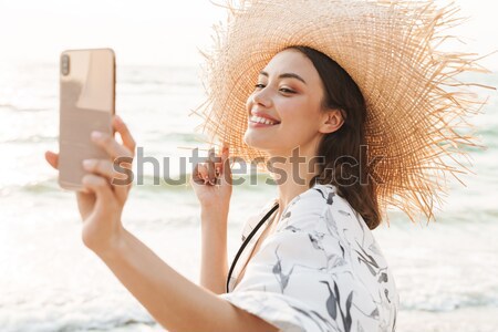 Photo of joyous blonde woman 20s smiling, and taking photo of su Stock photo © deandrobot