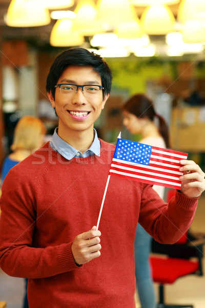 Cheerful asian student holding flag of USA Stock photo © deandrobot