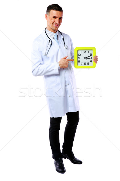 Portrait of a male doctor showing on clock over white background Stock photo © deandrobot