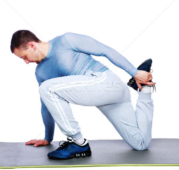 Sports man stretching over white background Stock photo © deandrobot