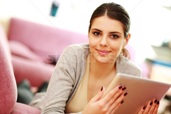 Young Beautiful Woman Lie On The Couch And Holding Tablet Computer