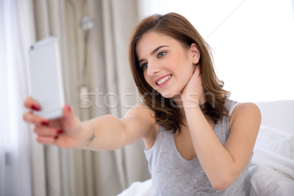 Happy woman making selfie photo with smartphone Stock photo © deandrobot