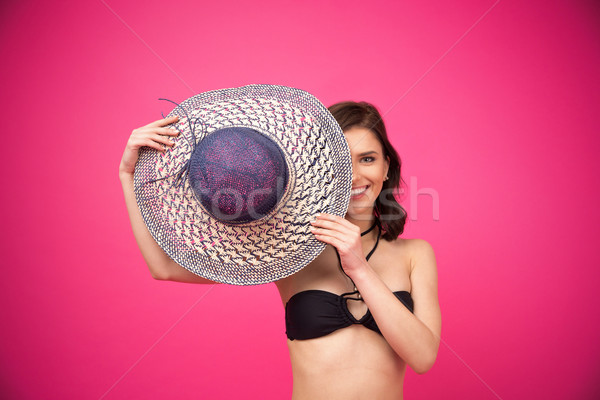 Happy woman covering her eye with hat Stock photo © deandrobot