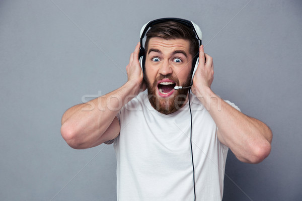 Retrato homem fones de ouvido gritando cinza música Foto stock © deandrobot