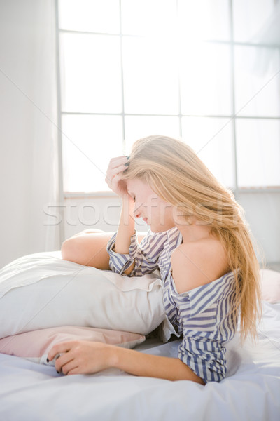 Tired fatigued woman lying on bed having a headache Stock photo © deandrobot