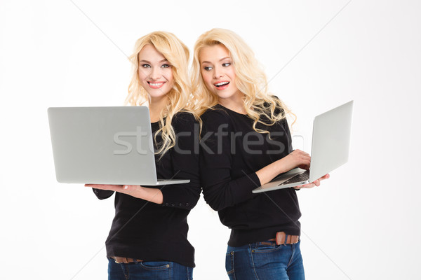 Gyönyörű derűs nővérek ikrek laptopok izolált Stock fotó © deandrobot