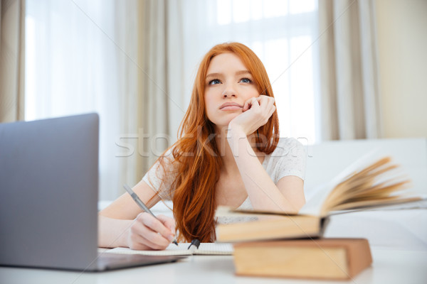 Nachdenklich Frau Sitzung Tabelle Hausaufgaben Rotschopf Stock foto © deandrobot