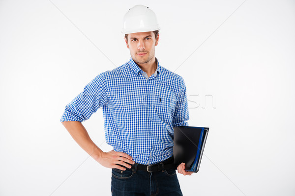 Handsome young man building engineer in helmet with folder Stock photo © deandrobot