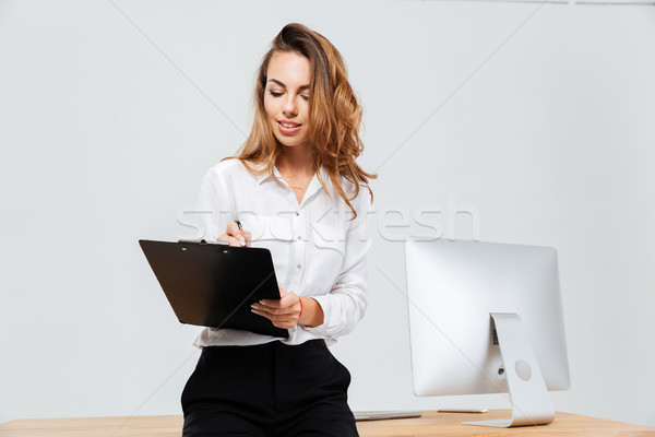 привлекательный молодые деловая женщина подписания документы служба Сток-фото © deandrobot