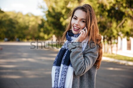 Beautiful young lady talking on her cellphone Stock photo © deandrobot