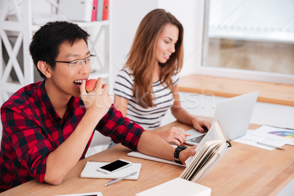 Foto stock: Estudante · alimentação · maçã · leitura · trabalhando · laptop