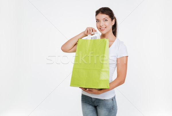 Woman holding purchasing after shopping and showing it to camera Stock photo © deandrobot