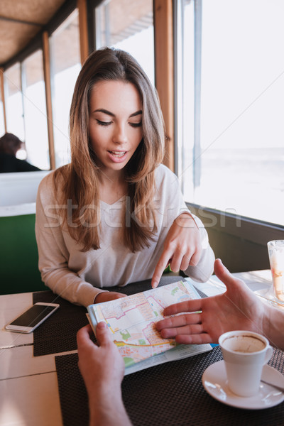 Vertical image of Man and girl with map in cafe Stock photo © deandrobot