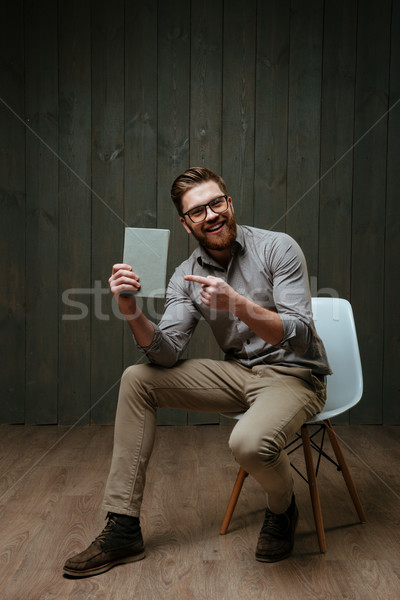 Cheerful bearded man pointing finger at book cover Stock photo © deandrobot