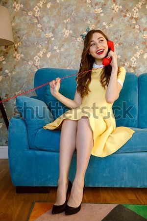 Young pin-up lady holding retro stationary phone. Stock photo © deandrobot