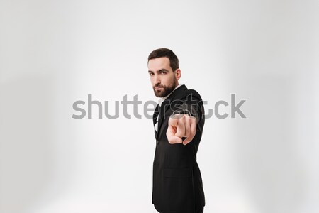 Jóképű fiatal szakállas üzletember mutat kamerába Stock fotó © deandrobot