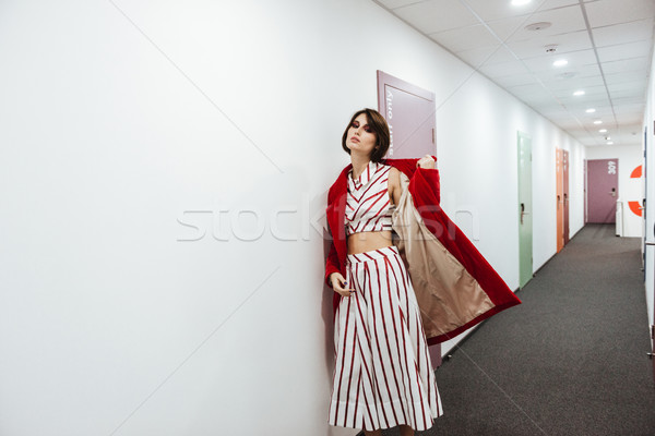 Woman in red coat walking in corridor Stock photo © deandrobot