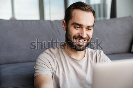 Smiling man reading book. Looking aside. Stock photo © deandrobot