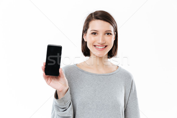 Amazing young caucasian woman showing display of phone. Stock photo © deandrobot