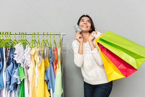 Cheerful woman holding shopping bags and talking by phone Stock photo © deandrobot