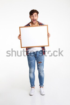 Full length portrait of an amused cheerful guy Stock photo © deandrobot