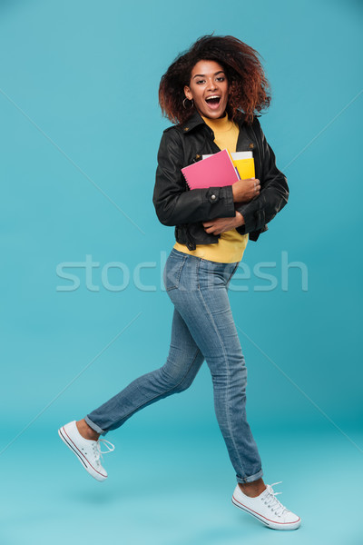 Full length image of Cheerful african woman in leather jacket Stock photo © deandrobot