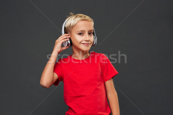 Happy little boy child listening music with headphones. Stock photo © deandrobot