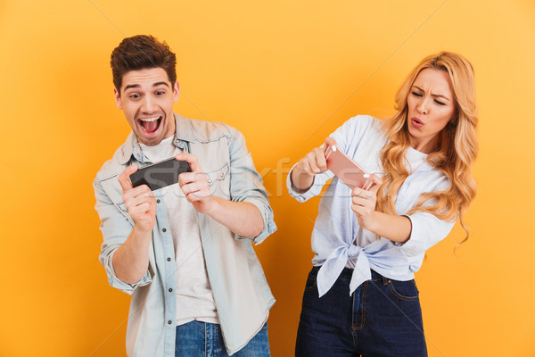 Image of young man and woman playing together and competing in v Stock photo © deandrobot