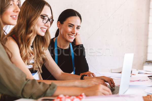 Three smiling young women clothes designers working Stock photo © deandrobot