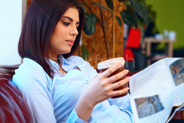 Attractive young woman reading the newspaper at office Stock photo © deandrobot