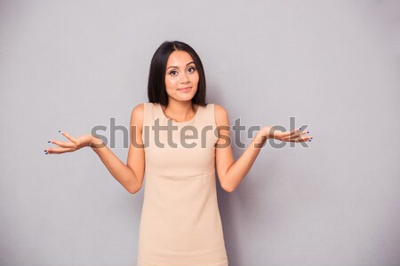 Stock photo: Portrait of a woman shrugging shoulders