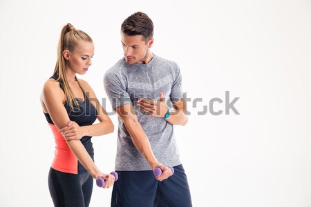 Male trainer teaching woman how to working with dumbbells Stock photo © deandrobot