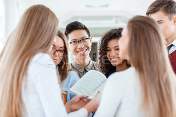 Smiling students speaking about boo Stock photo © deandrobot