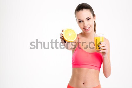 Fitness girl with orange half and glass of juice Stock photo © deandrobot